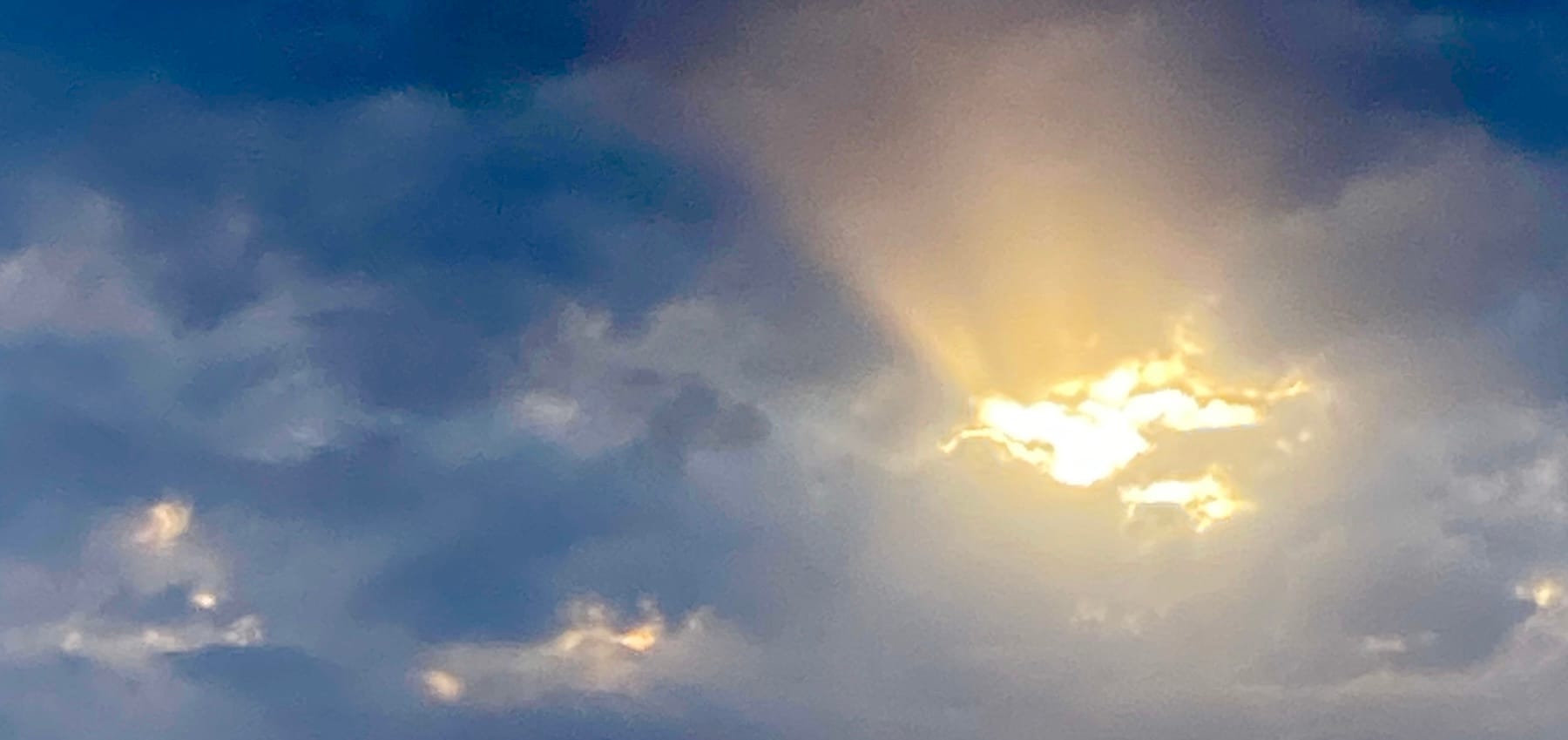 An image of clouds with sun shining through them